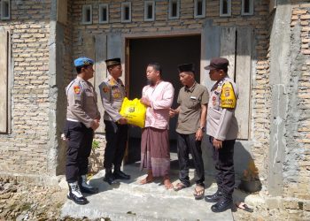 Kapolsek Belitang II, AKP. Aston L. Sinaga SH saat memberikan bantuan kepada Ismail, Jumat (24/3).