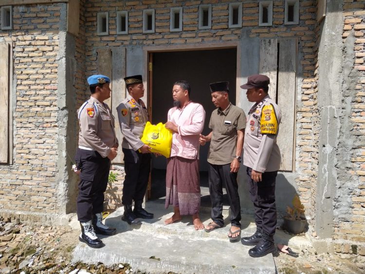 Kapolsek Belitang II, AKP. Aston L. Sinaga SH saat memberikan bantuan kepada Ismail, Jumat (24/3).