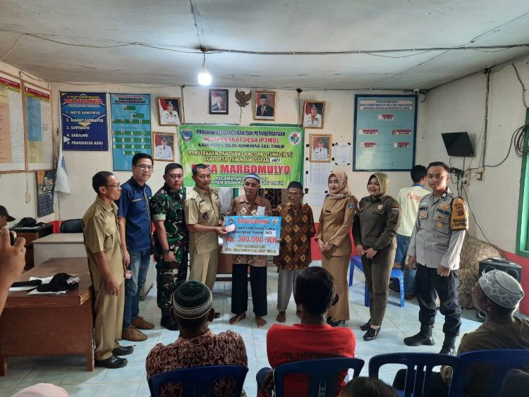 Bhabinkamtibmas Desa Margamulyo jajaran Polsek Belitang II, BRIGPOL Dody Yuristiato besama Kasi PMD Belitang II Evi Aprita SE, Babinsa Koramil Belitang II SERKA Sudarman, Kepala Desa Margomulyo Fransiscus Asisi, Pendamping Lokal Desa Muhtarinofa dan Asran, Sat Pol PP Riyani beserta Para Perangkat Desa Margomulyo saat penyerahan BLT kepada warga, Senin (27/3).