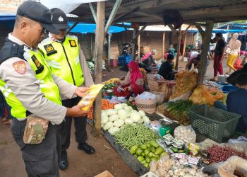 Kepala SPK Polsek Belitang II, Aiptu Made Sumatra didampingi Kanit Samapta, AIPTU. Tandian saat cek harga sembako, Jumat (31/3).