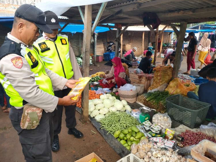 Kepala SPK Polsek Belitang II, Aiptu Made Sumatra didampingi Kanit Samapta, AIPTU. Tandian saat cek harga sembako, Jumat (31/3).