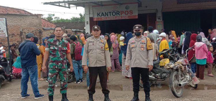 Personil Polsek Belitang II dan Koramil Belitang II saat PAM pembagian bantuan beras di kantor Pos, Senin (10/4).