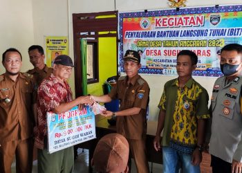 Bhabinkamtibmas BRIPTU. Azis Widodo SE saat dampingi warga pencairan BLT DD Tahap I Desa Sugih Waras, Selasa (11/4).