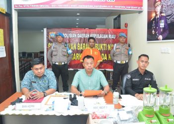 Tersangka MJ dan barang bukti 2.328 butir ekstasi saat diamankan, Jumat (5/5).