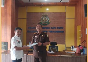 Djonggi Napitupulu saat menyerahkan laporan dugaan korupsi Dinas PUTR Kabupaten Toba diterima langsung oleh Kasi Intel Kejaksaan Negeri Toba Oloan Sinaga SH, Senin (11/9).