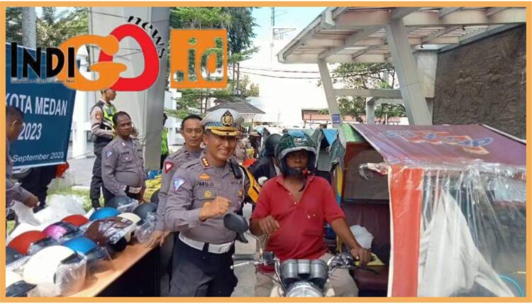 Direktur Lantas Polda Sumut, Kombes. Pol. Muji Ediyanto dan jajaran saat bagikan helm sni gratis bagi abang tukang betor, Senin (11/9).