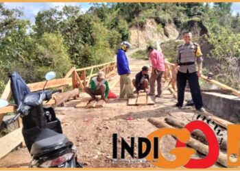 AIPTU. Pola Simanjuntak bersama warga saat perbaiki jalan, Sabtu (6/1).