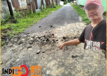 Viktor Sirait saat menunjukkan Kondisi bahu jalan yang saat ini rusak, Rabu (22/5).