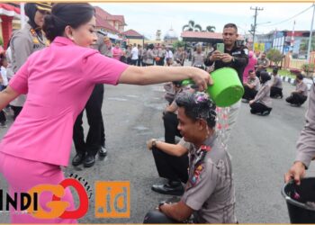 Ketua Bhayangkari Cabang Kota Deliserdang, Ny. Ine Raphael saat siram air kembang bunga kepada personil yang naik pangkat, Selasa (2/7).