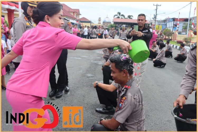 Ketua Bhayangkari Cabang Kota Deliserdang, Ny. Ine Raphael saat siram air kembang bunga kepada personil yang naik pangkat, Selasa (2/7).