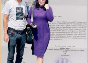 Elisabet Simanjuntak bersama suaminya saat di Mapolda Sumut, Senin (29/7).