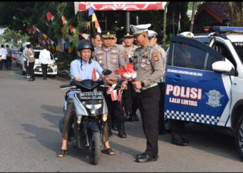 Polres Muara Enim Bagikan 100 Bendera Merah Putih kepada Para Pengguna Jalan