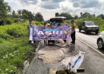 Polsek Lembak Tambal Jalan Lintas Palembang -Prabumulih Yang Berlubang