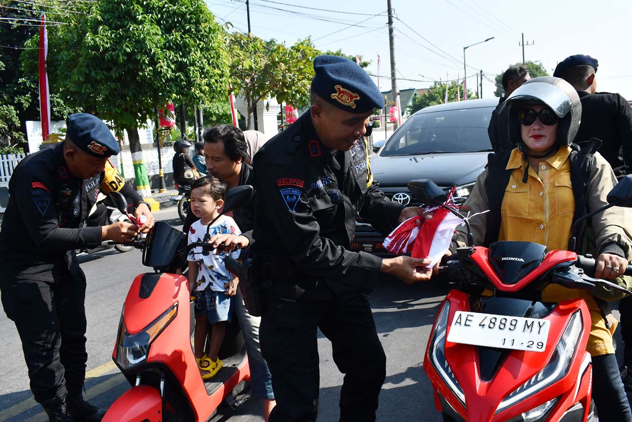 Brimob Bagikan Bendera Merah Putih di Madiun