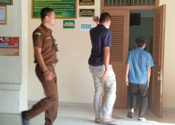 Kedua terdakwa Rendi Afriansyah dan Reyza Mahendra Lumbantobing dikawal Petugas Walta saat memasuki ruangan sidang
