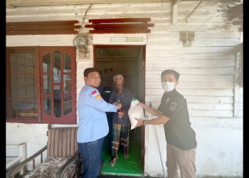 Dwi Ngai Sinaga, Direktur LBH IPK Sumut bersama tim saat menyerahkan bantuan kepada warga. (Foto Romulo Sinaga)