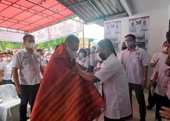 Rudi Zulham Hasibuan Ketua DPW Partai Perindo Sumut diberikan ulos oleh Ketua DPD Partai Perindo Medan, Dolli Sinaga saat peresmian kantor. (Foto Romulo)