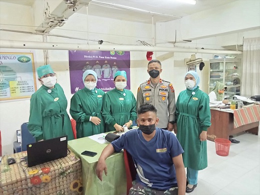 Kapolsek Medan Baru, Kompol Teuku Fathir Mustafa bersama para tenaga kesehatan saat pelaksanaan vaksinasi. (Foto Ist)