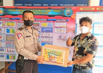 Kasi Humas Polres Simalungun IPDA Arwansyah Batubara saat menyalurkan paket lebaran kepada salah satu wartawan