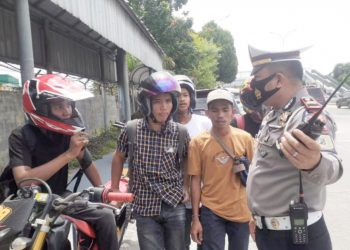 Petugas kepolisian menghentikan pengendera sepedamotor yang berusaha memasuki pintu tol Amplas. (Foto Ist)