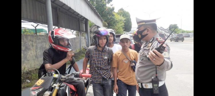 Petugas kepolisian menghentikan pengendera sepedamotor yang berusaha memasuki pintu tol Amplas. (Foto Ist)