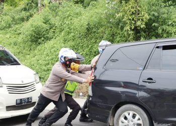 Wakapolrestabes Medan AKBP.Dr Yudhi Hery Setiawan SIK, MSi mendorong
mobil yang mogok. (Foto Ist)