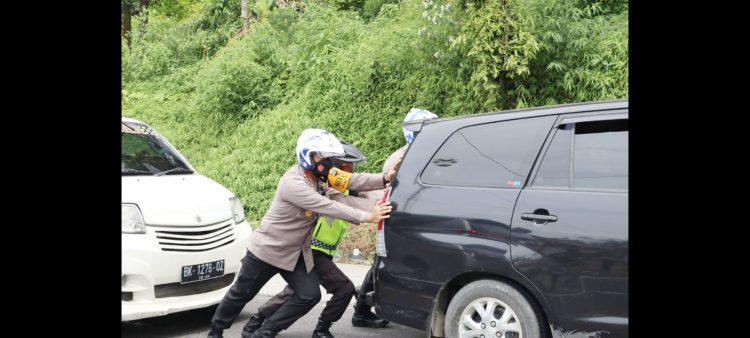Wakapolrestabes Medan AKBP.Dr Yudhi Hery Setiawan SIK, MSi mendorong
mobil yang mogok. (Foto Ist)