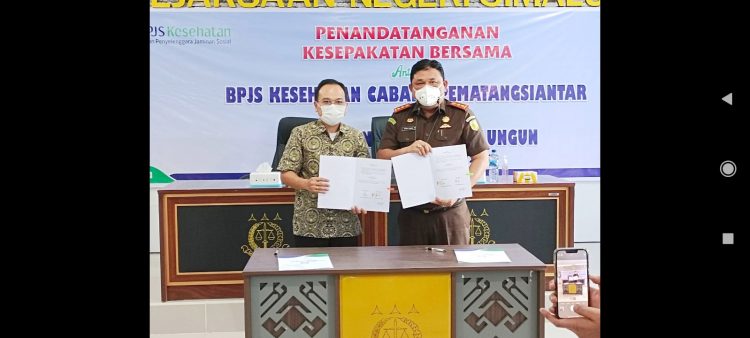 Kajari Simalungun Bobbi Sandri SH, MH dan Kepala BPJS Kesehatan Kantor Cabang (KC) Pematangsiantar, Dr K. Krismar Marbun tanda tangani MoU