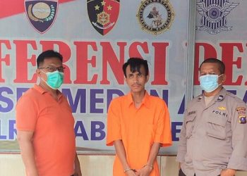 Pelaku pencuri pagar, M.Fauzi diapit polisi. (Foto Ist)