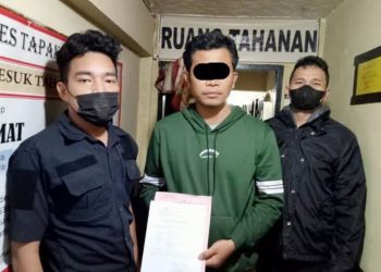 Oknum dosen, NTL diapit polisi. (Foto Ist)