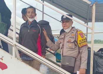 Aiptu Haris Fadillah personil Labuhanbatu mengantarkan kakek Muhadi di Bandara Kualanamu Internasional Airport. (Foto Ist)