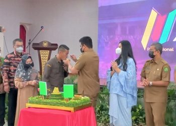 Bobby Nasution Wali Kota Medan saat hadir di HUT ke-29 PUD Pasar Medan serta memberikan kue kepada Suwarno Dirut PUD Pasar. (Foto Romulo)