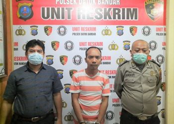 Pelaku Daniel Arifin Simanjuntak diapit polisi Polsek Datuk Bandar