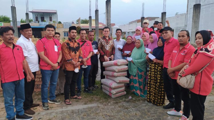 Ketua DPC PDI Perjuangan Kota Medan Hasyim dan pengurus saat menyerahkan bantuan ke korban kebakaran di Jalan Bajak V, Medan Amplas. (Foto Ist)