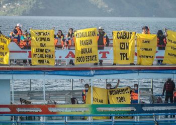 Pembentangan banner raksasa oleh aktifis perempuan di Danau Toba. (Foto Ist)
