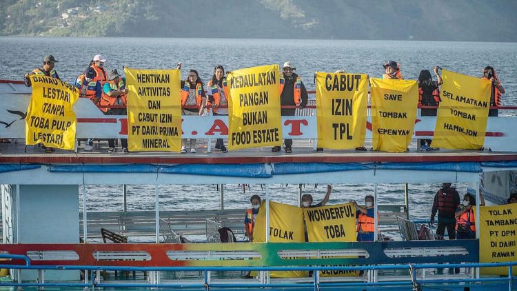 Pembentangan banner raksasa oleh aktifis perempuan di Danau Toba. (Foto Ist)