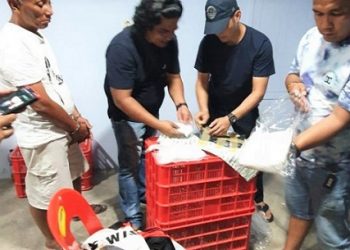 Pelaku menyaksikan polisi saat menggeledah barang bukti (Foto Ist)
