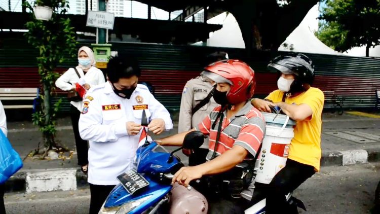 Pokdarkamtibmas bagikan bendera merah putih dipimpin Eric kepada pengendara Sambut HUT RI ke 77. (Foto Ist)