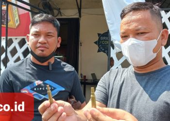 Dwi Ngai Sinaga, SH dan Bennri Pakpahan, SH menunjukan selosong peluru. (Foto Romulo)