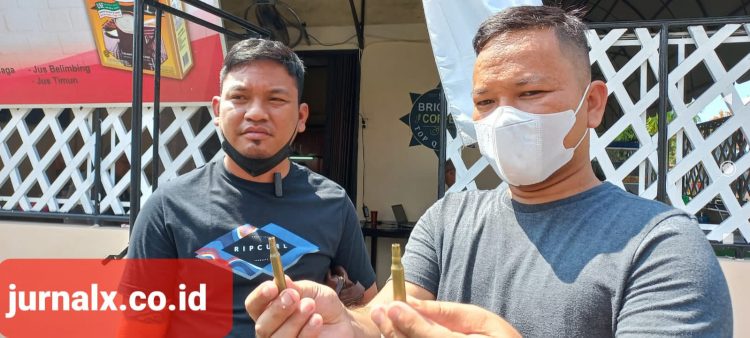 Dwi Ngai Sinaga, SH dan Bennri Pakpahan, SH menunjukan selosong peluru. (Foto Romulo)