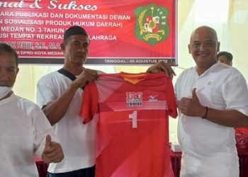 Anggota DPRD Medan, Robi Barus saat menyerahkan bantuan baju olahraga voli di Jalan Dodik, Medan Helvetia. (Foto Romulo)