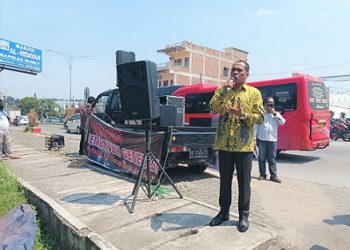 Anggota DPRD Sumut dari Partai Golkar, Zainuddin Purba mengelar aksi unjuk rasa tunggal di depan Mapolda Sumut. (Foto Romulo)