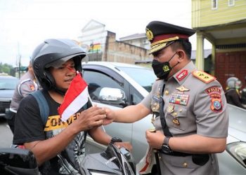 Kapolda Sumut Irjen Pol. Drs. R.Z. Panca Putra saat bagikan bendera merah putih kepada masyarakat. (Foto Ist)