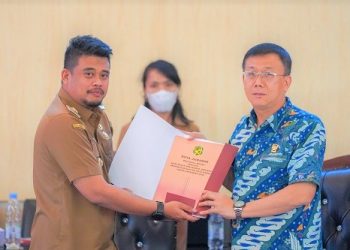 Wali Kota Medan Bobby Nasution saat menyerahkan Nota Jawaban Wali Kota Medan tentang Rancangan P-APBD TA 2022 kepada Ketua DPRD Medan, Hasyim. (Foto Ist)