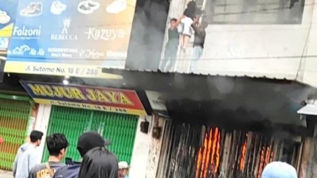 Kebakaran satu unit rumah toko Jalan Sutomo /Pasar Sambu petugas tampak melakukan evakuasi korban, Medan Timur. (Foto Ist)