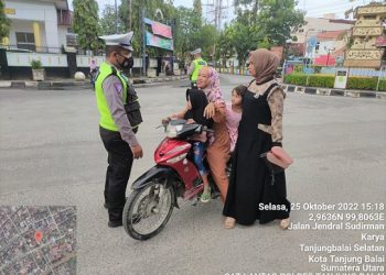 Personil Sat Lantas menegur warga yang tidak memakai helm
