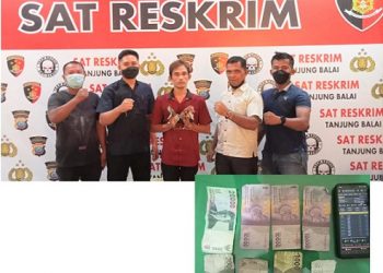 Pelaku AS diapit personil Sat Reskrim Polres Tanjungbalai dan barang bukti yang diamankan