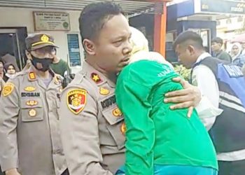 Kapolsek Medan Timur, Kompol Rona Tambunan menggendong wanita lansia pingsan mengikuti gerak jalan. (Foto Ist)