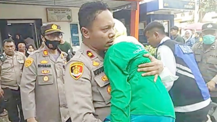 Kapolsek Medan Timur, Kompol Rona Tambunan menggendong wanita lansia pingsan mengikuti gerak jalan. (Foto Ist)