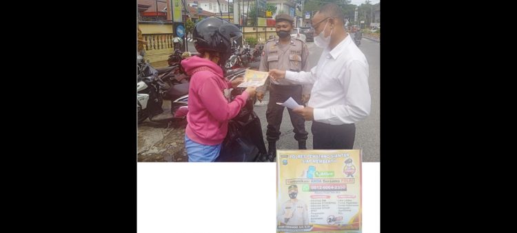 IPDA Mianto saat menyebarkan stiker layanaan No.WA Centre kepada masyarakat didepan Mako Polres Siantar.